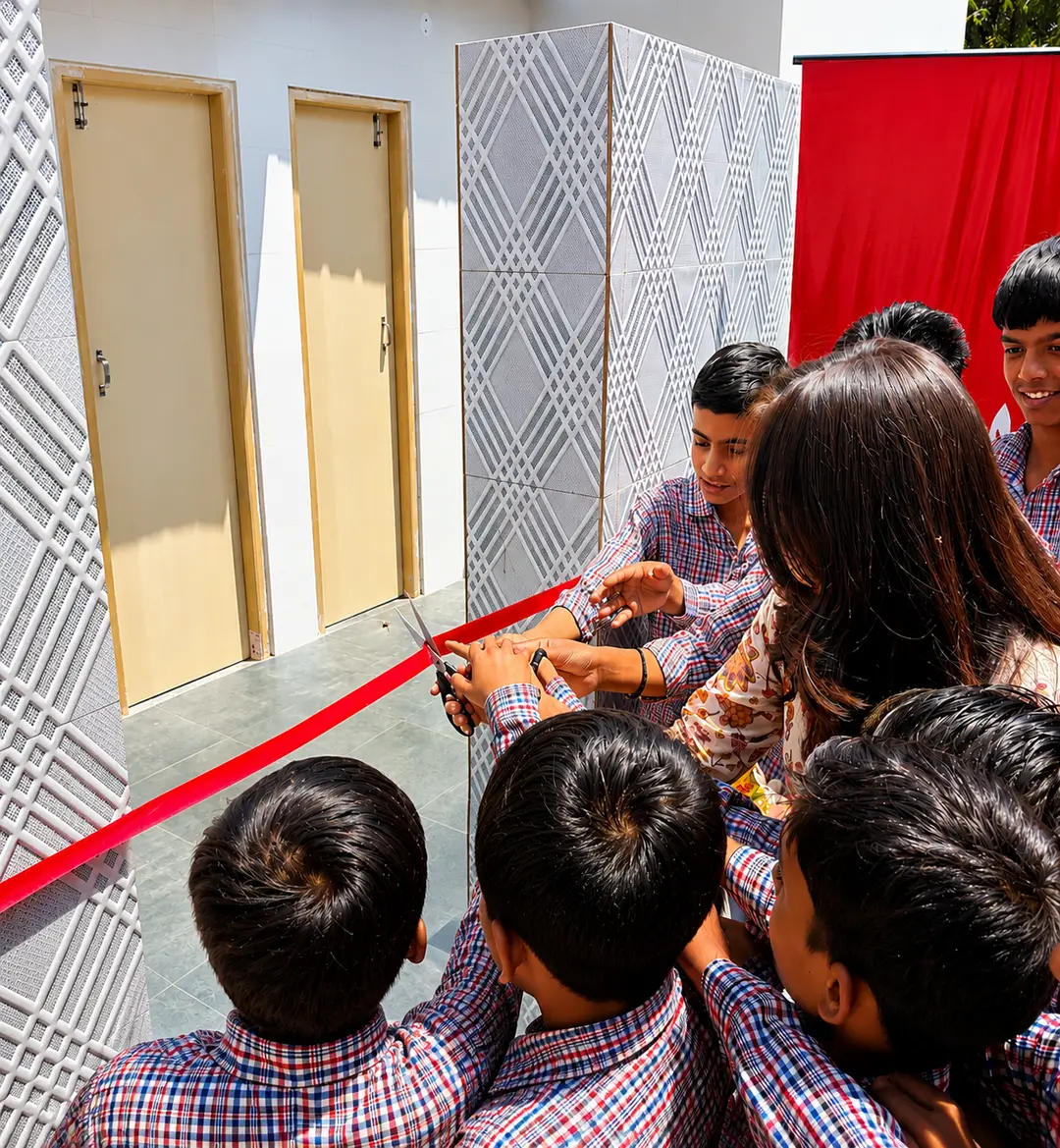 Students cutting the ribbon at a newly built school washroom